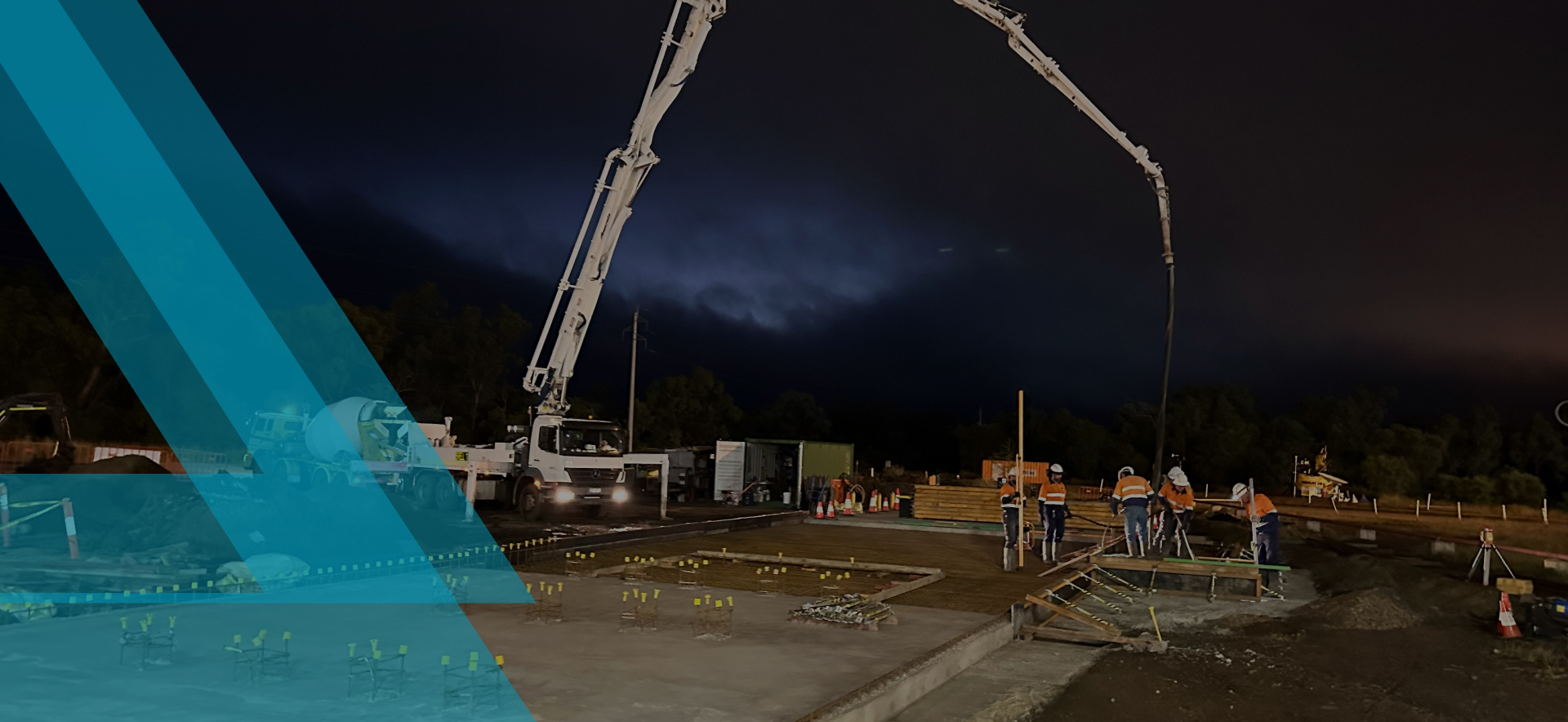 Nighttime construction with concrete pump, highlighting Slamm Services' civil and construction expertise.